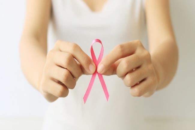 אישה מחזיקה סרט ורוד למודעות לסרטן השד, אקסמסטן לטיפול בסרטן השד